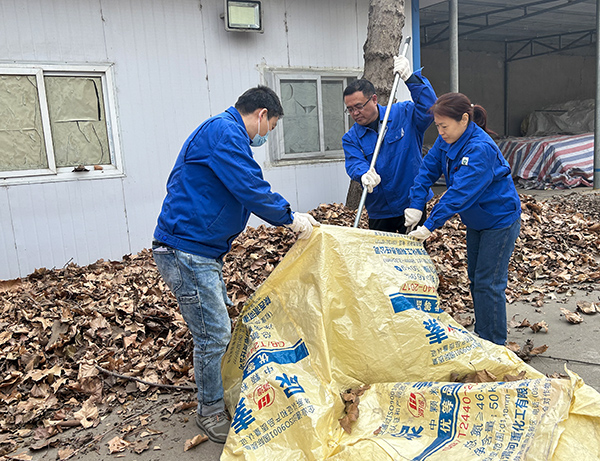 1679475783909296.jpeg 總經理李留道手拿耙子清理落葉。(副圖).jpg