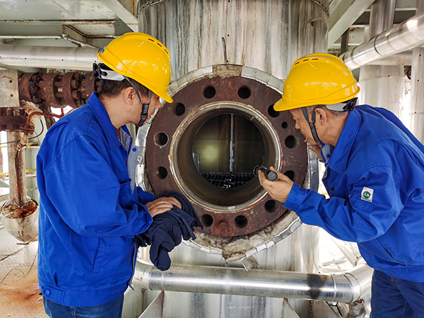 1697794756101937.jpeg 尿素車間曾迎軍、李廣志檢查高壓洗滌器內部是否有腐蝕情況.jpg